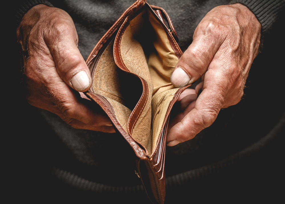Empty wallet in the hands of an elderly person