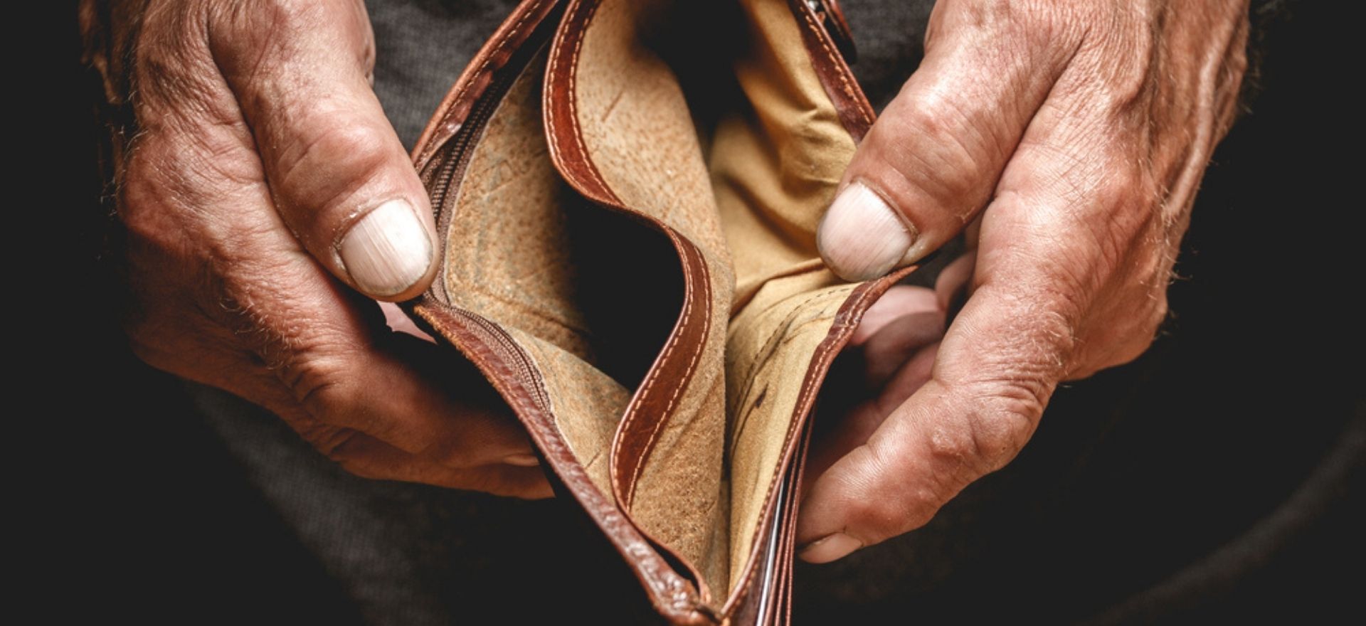 Empty wallet in the hands of an elderly person